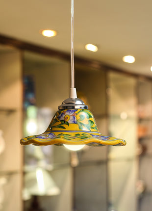 Colorful pendant light with a decorative glass shade against a blurred indoor background