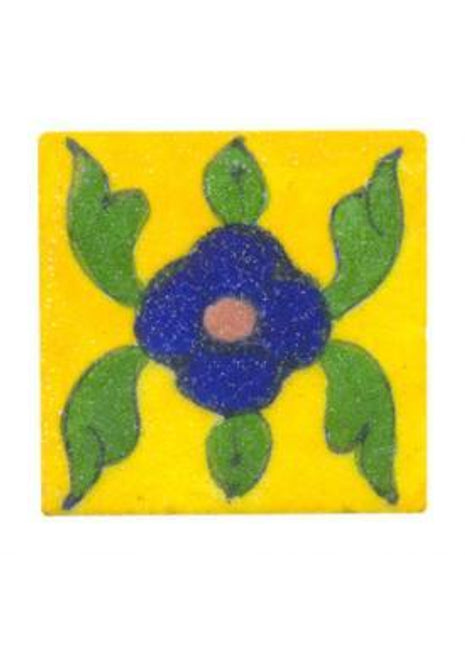 Green leaves with blue flower on yellow tile