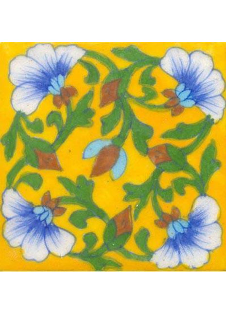 Blue & white flower with green leaves on yellow tile.
