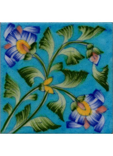 Two Blue flowers with green leaves on turquoise tile
